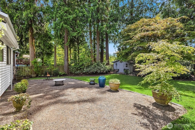 view of yard with a fire pit, an outbuilding, and a patio area