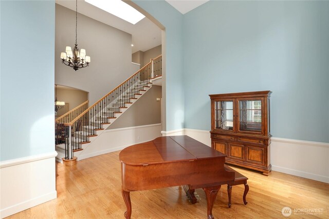 25846 NE 4th Pl, Sammamish, WA 98074 - sitting room featuring arched walkways, light wood-style floors, stairs, and a high ceiling