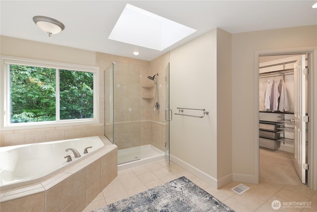 25846 NE 4th Pl, Sammamish, WA 98074 - full bathroom with a skylight, tile patterned flooring, a shower stall, and a walk in closet