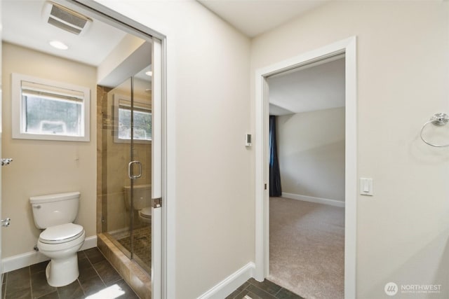 bathroom featuring toilet, baseboards, a shower stall, and tile patterned floors