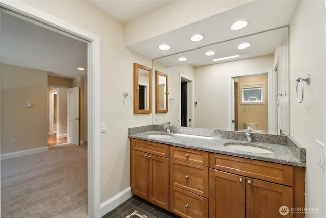 bathroom featuring toilet, recessed lighting, double vanity, and baseboards
