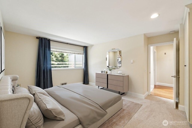 bedroom with light colored carpet, recessed lighting, and baseboards
