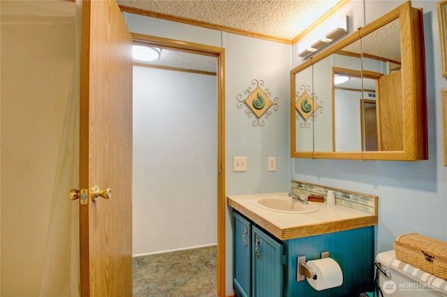bathroom featuring vanity, a textured ceiling, toilet, and ornamental molding