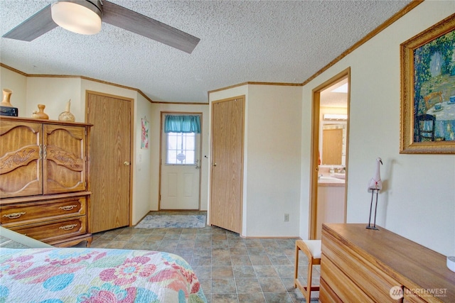 bedroom with crown molding, a textured ceiling, and multiple closets