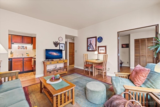 living room with light wood finished floors, baseboards, and indoor bar