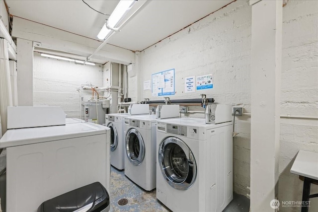 common laundry area with water heater and washer and clothes dryer