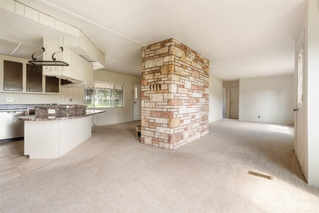 252 Romerman Rd, Chehalis, WA 98532 - kitchen featuring dark stone counters, light colored carpet, visible vents, wooden walls, and stainless steel dishwasher