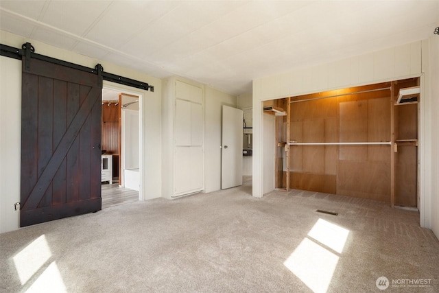 252 Romerman Rd, Chehalis, WA 98532 - unfurnished bedroom featuring wooden walls, carpet flooring, and a barn door