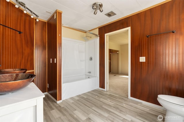 252 Romerman Rd, Chehalis, WA 98532 - bathroom featuring toilet, wood walls, shower / tub combination, and wood finished floors