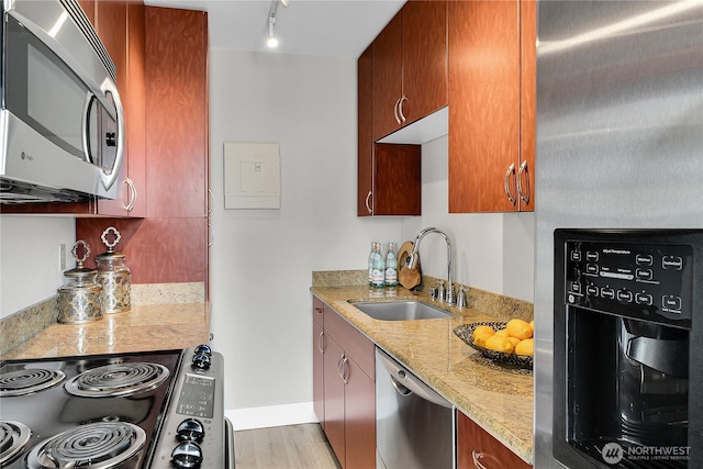 1105 Spring St Unit 1306, Seattle, WA 98104 - kitchen with appliances with stainless steel finishes, a sink, light stone countertops, track lighting, and baseboards