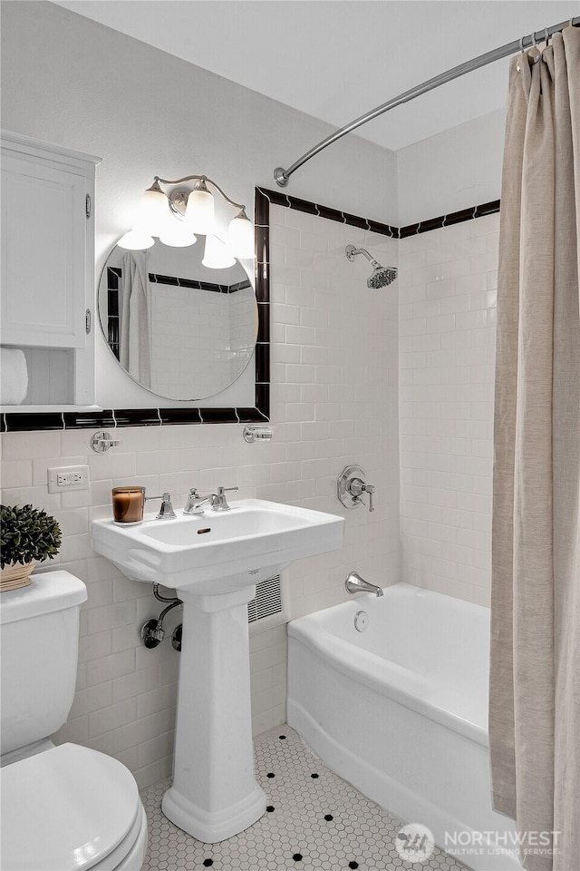 1105 Spring St Unit 1306, Seattle, WA 98104 - bathroom with shower / bath combo, toilet, tile patterned flooring, and tile walls