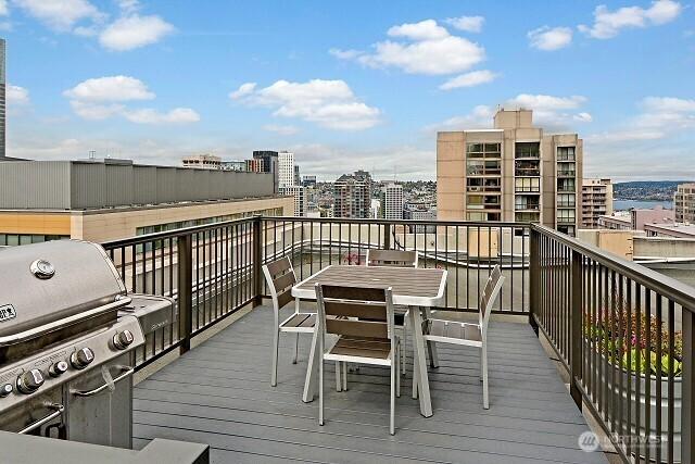 1105 Spring St Unit 1306, Seattle, WA 98104 - wooden deck featuring a view of city, a grill, and outdoor dining area