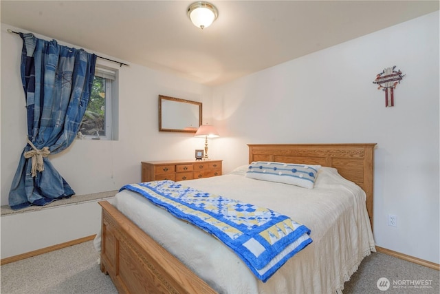 bedroom with light colored carpet and baseboards