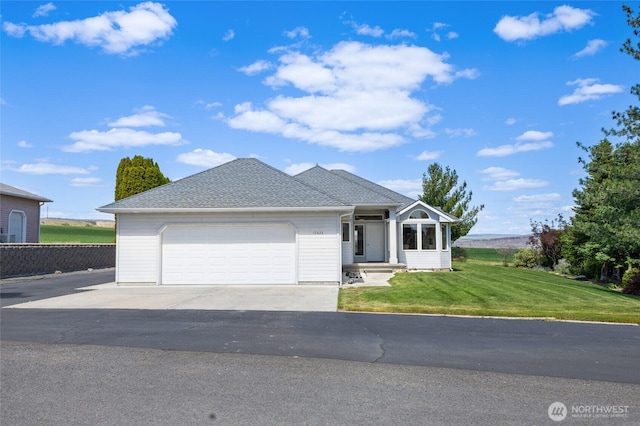 ranch-style house featuring driveway, a garage, a shingled roof, and a front yard
