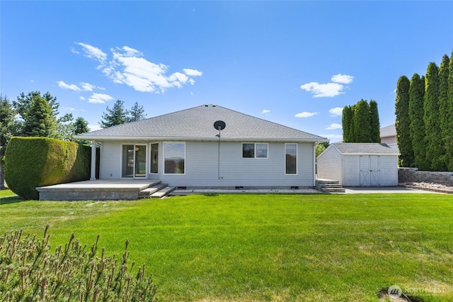 back of house featuring a yard, an outdoor structure, a storage shed, and crawl space