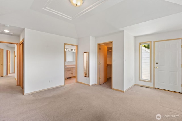 foyer featuring baseboards and light colored carpet