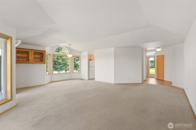 unfurnished living room with light carpet, lofted ceiling, and baseboards