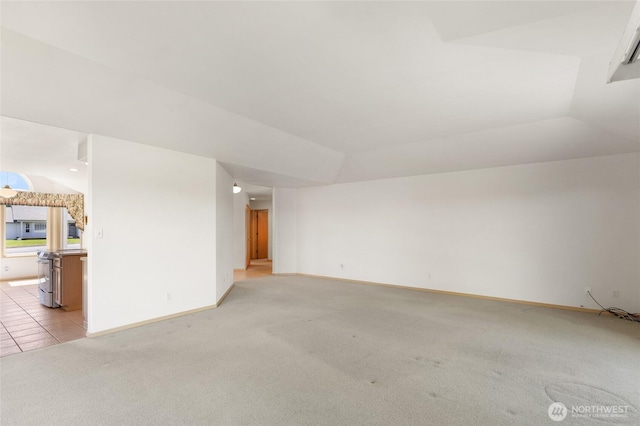 unfurnished living room featuring baseboards, light carpet, and light tile patterned floors