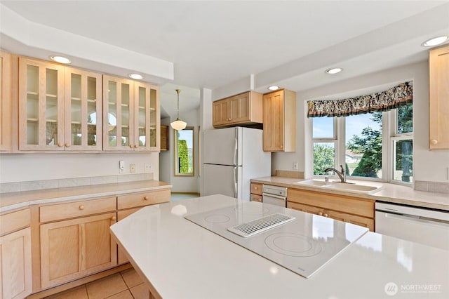 kitchen with light brown cabinetry, recessed lighting, white appliances, a sink, and light countertops