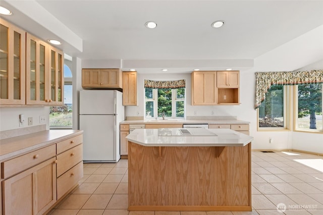kitchen with light brown cabinetry, recessed lighting, light tile patterned floors, white appliances, and a sink