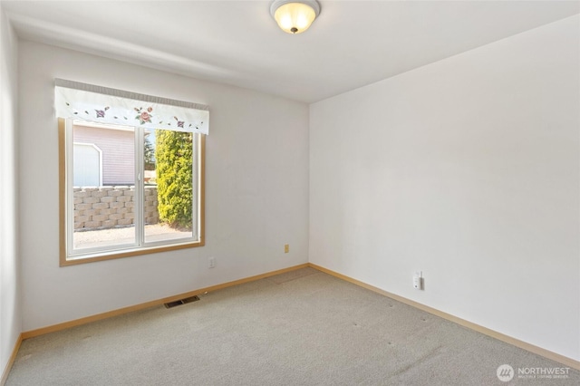 unfurnished room with carpet, visible vents, and baseboards