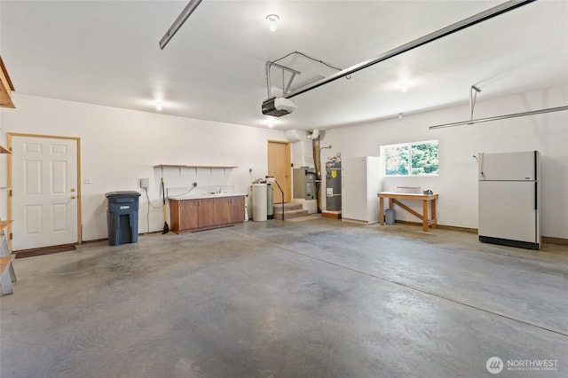 garage with freestanding refrigerator, secured water heater, and a garage door opener