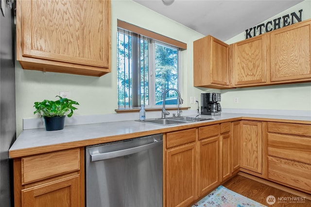 kitchen with dishwasher, a sink, light countertops, and freestanding refrigerator