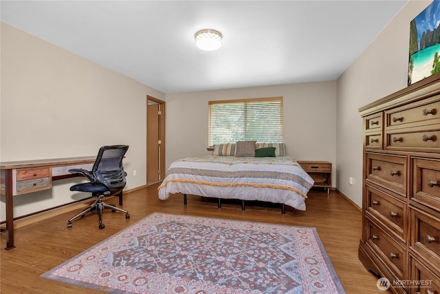 bedroom with light wood finished floors and a desk