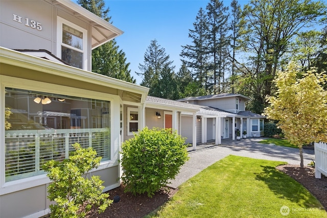 exterior space with driveway, a shingled roof, a front yard, and a garage