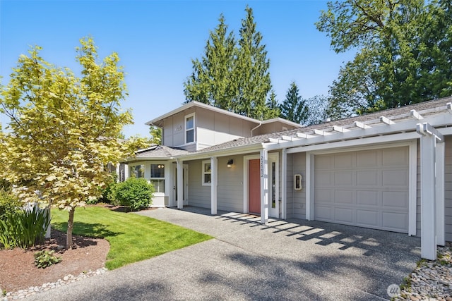 traditional-style home with a front yard, aphalt driveway, an attached garage, and board and batten siding