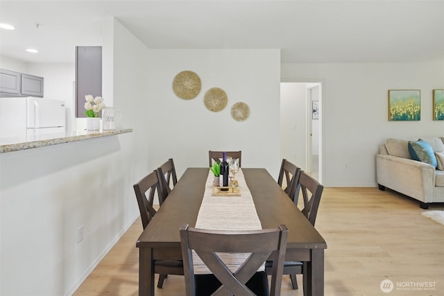 dining space with light wood finished floors, baseboards, and recessed lighting