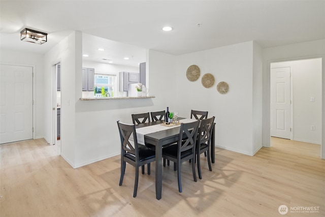 dining area featuring baseboards, light wood finished floors, and recessed lighting