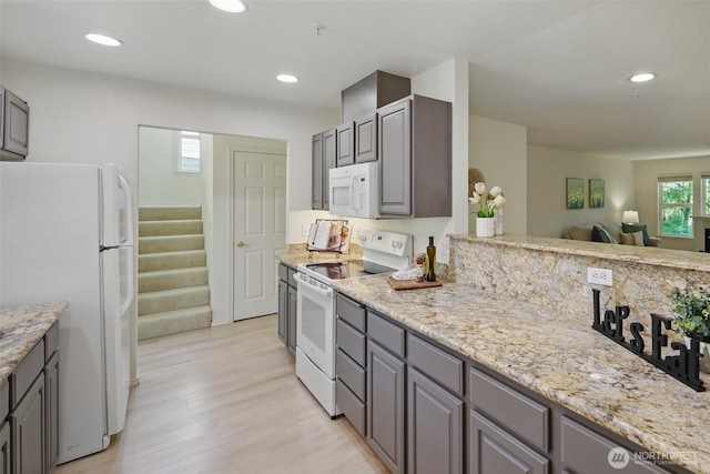 kitchen with recessed lighting, gray cabinetry, light wood-style floors, and white appliances