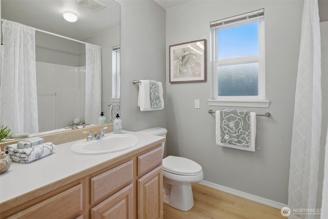 bathroom featuring toilet, baseboards, visible vents, vanity, and wood finished floors