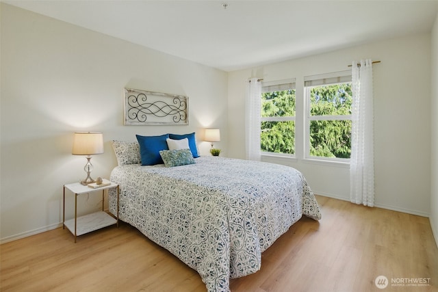 bedroom with wood finished floors and baseboards