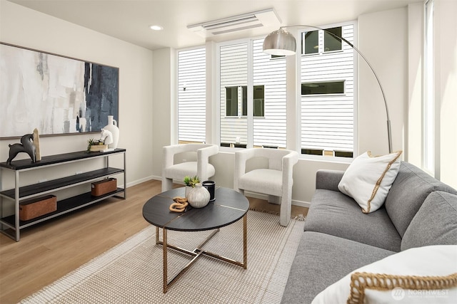 living room featuring light wood-style flooring, baseboards, and recessed lighting