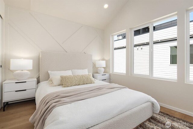 bedroom featuring wood finished floors, vaulted ceiling, baseboards, and recessed lighting