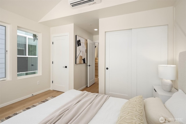 bedroom with light wood-type flooring, baseboards, a closet, vaulted ceiling, and recessed lighting