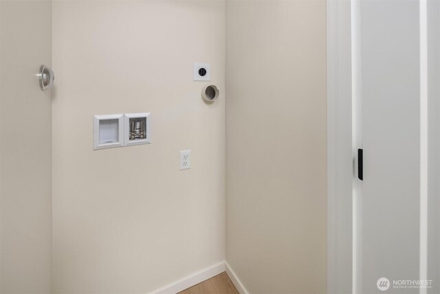 clothes washing area with hookup for an electric dryer, washer hookup, and baseboards