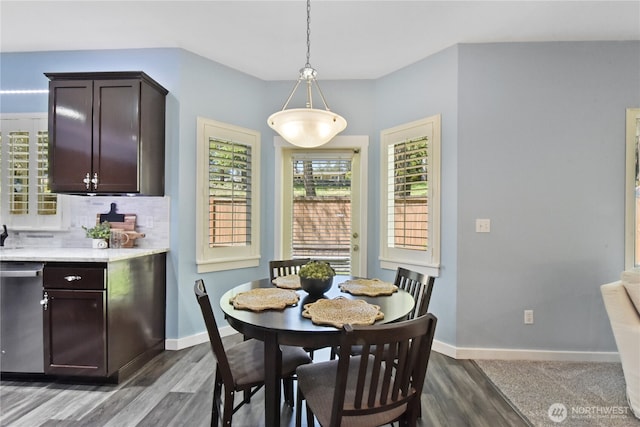 dining area featuring dark wood-style flooring and baseboards