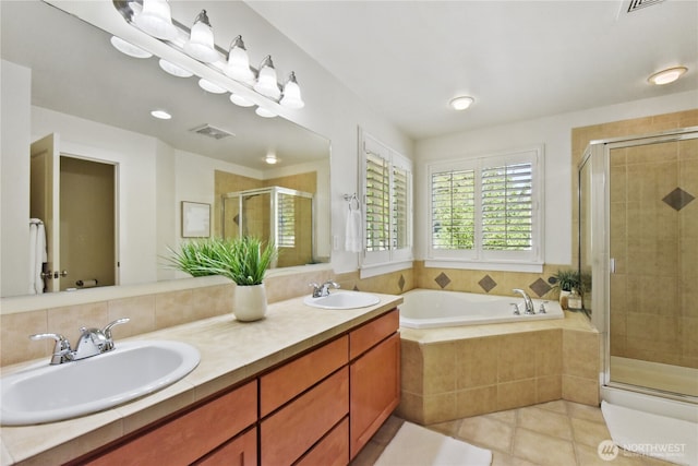 full bath featuring a shower stall, tile patterned flooring, a garden tub, and double vanity