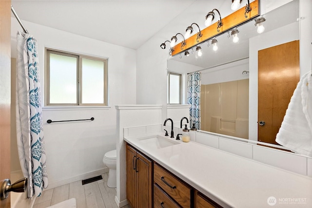bathroom featuring toilet, curtained shower, vanity, and baseboards
