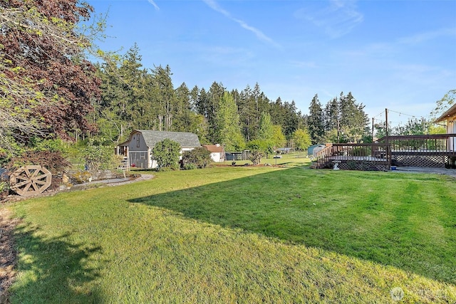 view of green lawn featuring a wooden deck