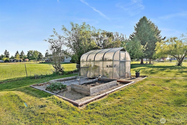 entry to storm shelter with a yard, an outbuilding, and a greenhouse