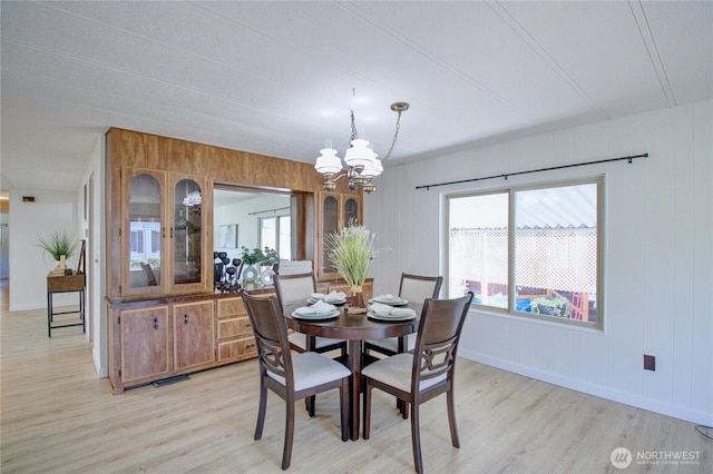 dining room with an inviting chandelier, visible vents, light wood-style flooring, and baseboards