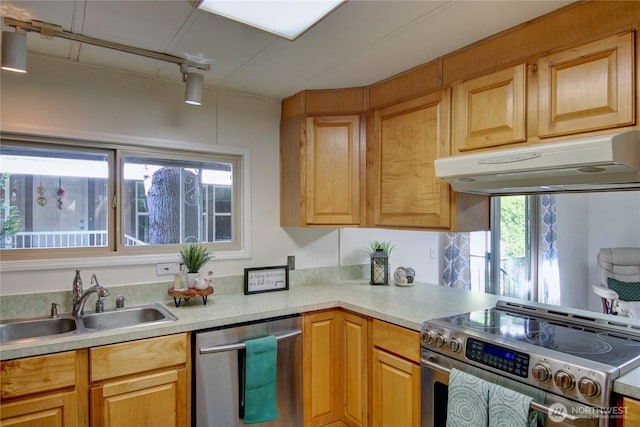kitchen featuring light countertops, a sink, appliances with stainless steel finishes, and under cabinet range hood