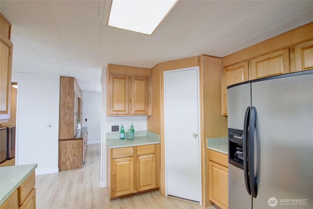kitchen featuring light wood-style flooring, light brown cabinetry, light countertops, and stainless steel refrigerator with ice dispenser