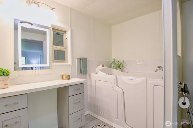 bathroom featuring vanity and a garden tub