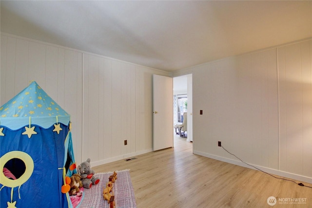 rec room with baseboards, visible vents, and wood finished floors
