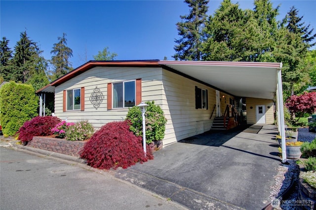 view of side of property with driveway and a carport